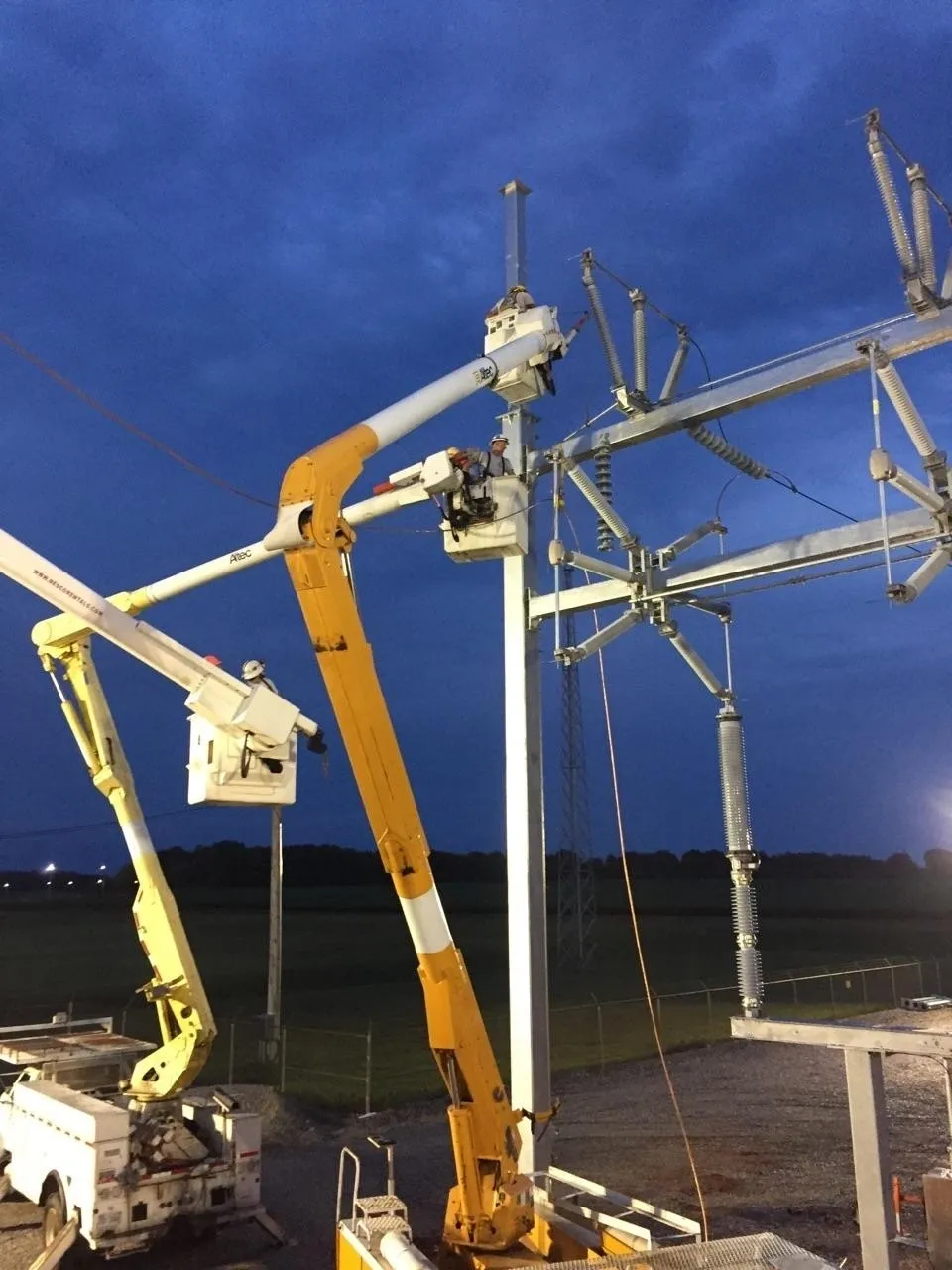 A group of people in cherry-picker 's working on power lines.